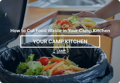 Uneaten salad and vegetables being scraped from a plate into a kitchen waste bin.