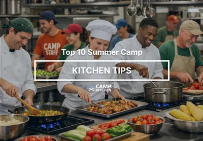 A camp kitchen crew in aprons and chef whites cooking together at the range, trays of fresh vegetables on the counter in front of them.